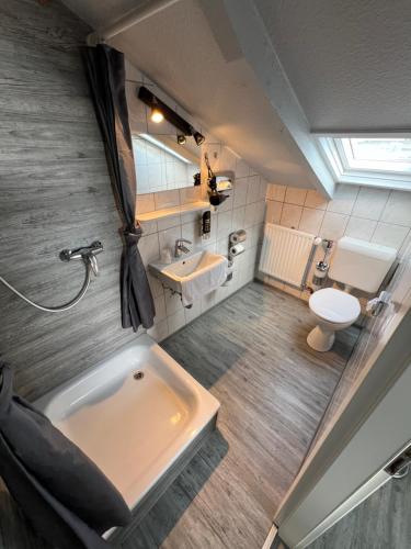 a bathroom with a tub and a sink and a toilet at Hotel Tum Stüürmann in Büsum