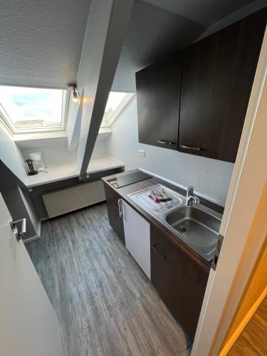 a small kitchen with a sink and a window at Hotel Tum Stüürmann in Büsum