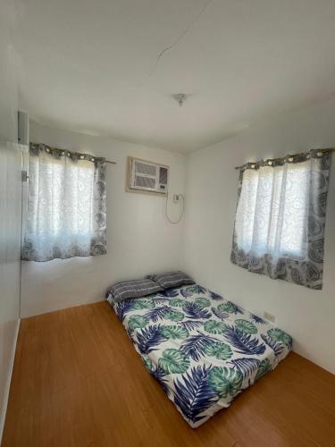 a bedroom with a bed and two windows at tadzmahal in Pagadian