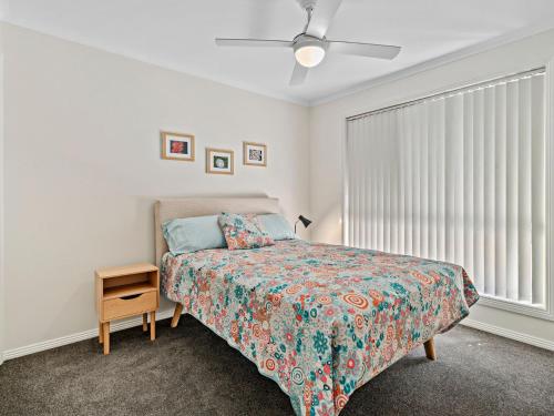 1 dormitorio con 1 cama, mesita de noche y ventana en Pat's Place Sun and Lake, en Mulwala
