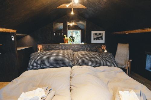 ein Bett mit zwei Kissen auf einem Zimmer in der Unterkunft Lilla Dalbo "Adults only", Ulvön Höga Kusten in Ulvöhamn