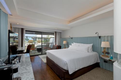 a hotel room with a bed and a balcony at The Boathouse Phuket-SHA Plus in Kata Beach