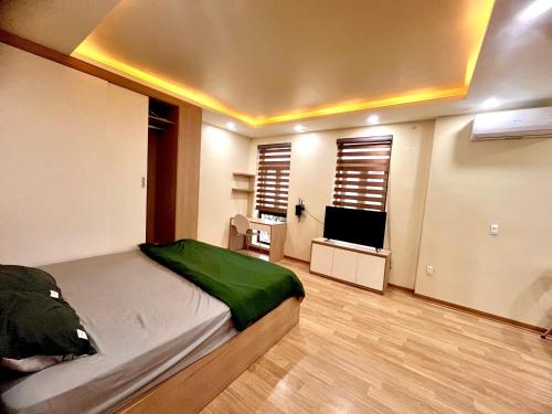a bedroom with a bed and a flat screen tv at HPT Home II Hoàng Huy Riverside Apartment - Homestay chuỗi căn hộ Hải Phòng in Hai Phong