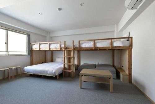 a room with two bunk beds and a table at DD HOTEL 中洲 in Fukuoka
