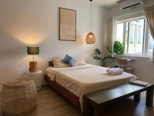 - une chambre avec un lit, une table et une fenêtre dans l'établissement Notre Maison 5 Saigon close Walking street in Thao Dien D2, à Hô-Chi-Minh-Ville