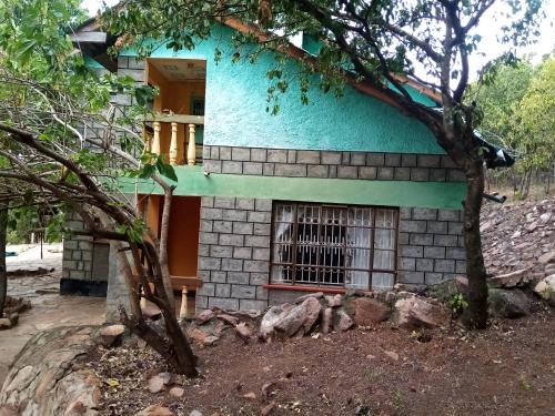 a blue building with a window in front of it at D-TURA Guest House in Sekenani