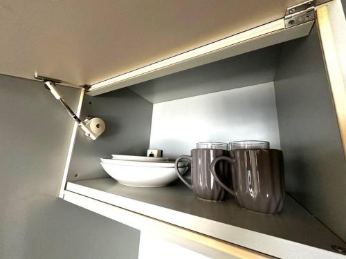Un estante con dos tazas y un tazón. en 9-5 NEW OPEN　美室駅近で眺望良好　駐車場予約可, en Minami-jūichijō