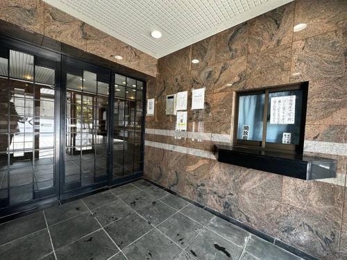 een lobby met een stenen muur en een raam bij 9-5 NEW OPEN　美室駅近で眺望良好　駐車場予約可 in Minami-jūichijō