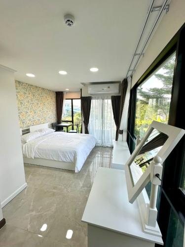 a bedroom with a bed and a large window at Arunsakhon luxury condo in Ban Khok Kham