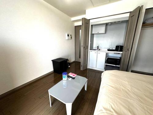 Una habitación con una cama y una mesa y una cocina. en 9-5 NEW OPEN　美室駅近で眺望良好　駐車場予約可, en Minami-jūichijō