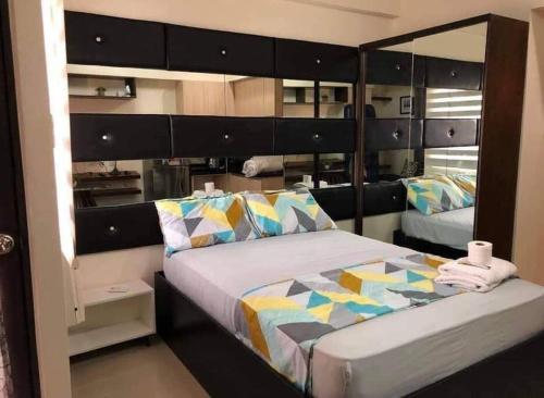 ein Schlafzimmer mit einem großen Bett und einem großen Spiegel in der Unterkunft Mabolo Garden Flat A10 Free pool Near Ayala Mall in Cebu City