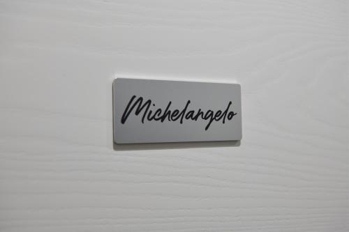 a white sign with the word mitzender written on it at Eletta Guest House in Rome