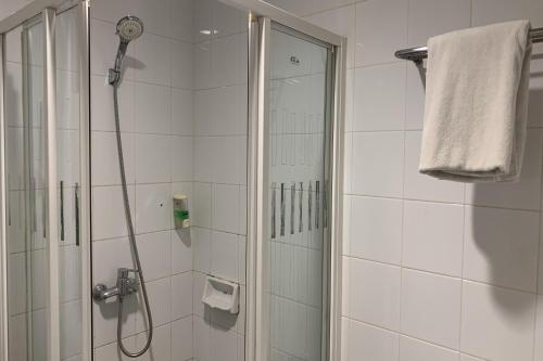 a bathroom with a shower with a glass door at Hotel Glodok Plaza in Jakarta