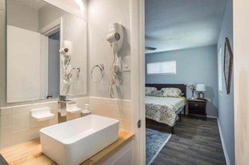 baño con lavabo blanco y cama en Cheerful 3 BR 2BA Home in Great Neighborhood!, en Jacksonville