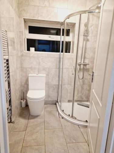 a bathroom with a shower and a toilet in it at Malborough - a lovely 3 bed house for short or long-term stays in Derby
