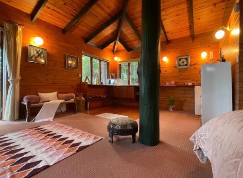 a bedroom with a bed and a living room at Krishna Farm Retreat in Coolabine