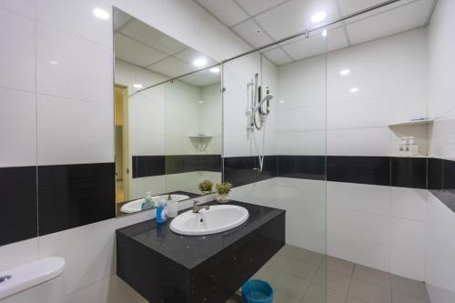 W łazience znajduje się umywalka i lustro. w obiekcie Sky Suites w mieście George Town