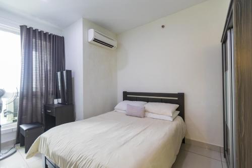 a bedroom with a large white bed with two pillows at Sky Suites in George Town