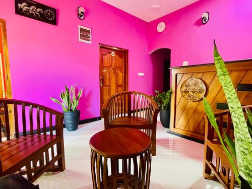 a room with pink walls and a table and chairs at Hema Holiday Villa in Trincomalee