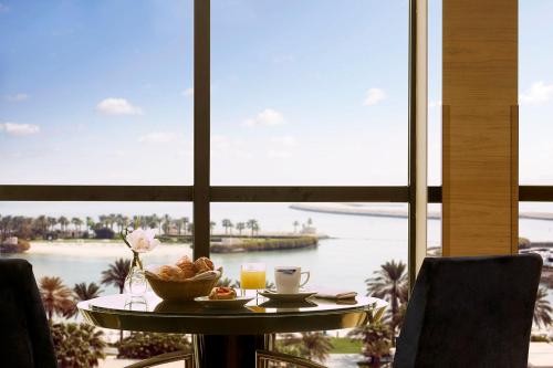 a table with a bowl of food and a view of the water at The Ritz-Carlton, Bahrain in Manama