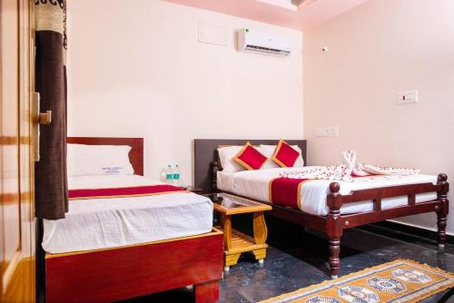 - une chambre avec 2 lits et une table dans l'établissement MUTHU RESIDENCY, à Thanjavur