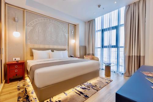 a bedroom with a large bed and a large window at Hilton Garden Inn Samarkand Sogd in Samarkand