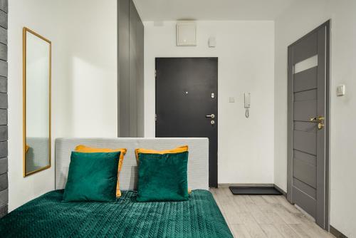 sypialnia z łóżkiem z 2 zielonymi poduszkami w obiekcie Lumina apartments with parking, balcony Lodz w Łodzi