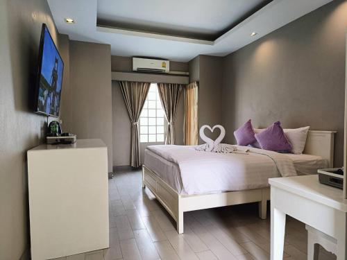 ein Schlafzimmer mit einem Bett mit einem Herz darauf in der Unterkunft The Guest Chang Moi Hotel in Chiang Mai