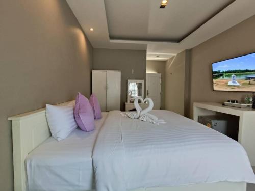 The Guest Chang Moi Hotel في شيانغ ماي: غرفة نوم بسرير ابيض كبير عليها بجعتين