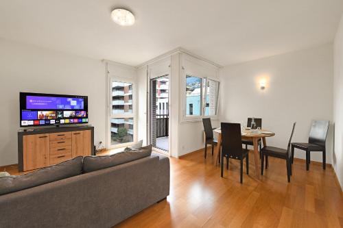 uma sala de estar com um sofá e uma mesa com cadeiras em Imbarcadero Apartment - Happy Rentals em Locarno