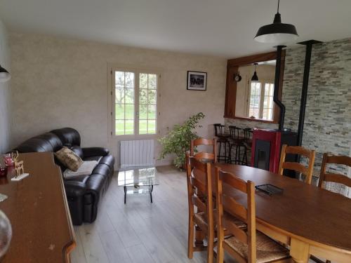 a living room with a table and a couch at Maison à la campagne in Saint-Pierre-les-Étieux