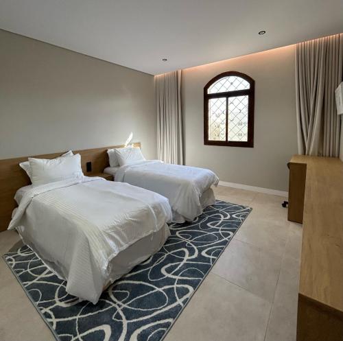 a bedroom with two beds and a rug at Maz Apartments in Al Madinah