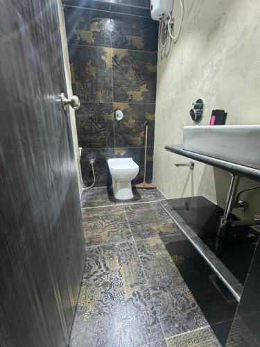a bathroom with a toilet and a sink at Backpackers Villa Mumbai in Mumbai