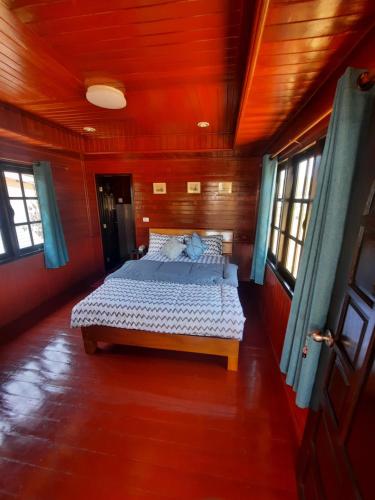 a bedroom with a bed in a wooden room at Lucky Bungalow in Khao Lak