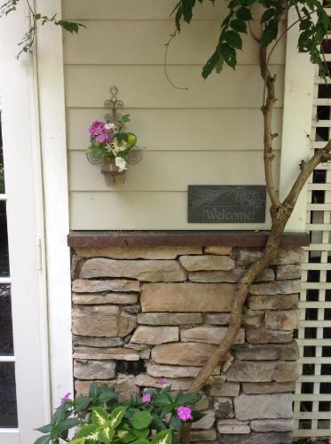 a sign on the side of a house with flowers at Haddock Hill House in Old Chatham