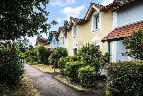 une rangée de maisons avec des buissons et une allée dans l'établissement Résidence Le Hameau du Lac - maeva Home - Appartement 2 pièces 4 personnes - Confort MAE-0524, à Marciac