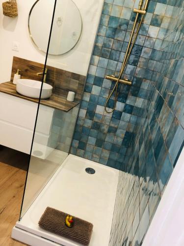 une salle de bain avec une douche avec un lavabo et un miroir dans l'établissement Ô Septième Ciel, à La Grande Motte