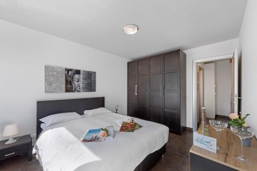 sypialnia z dużym białym łóżkiem z drewnianym zagłówkiem w obiekcie Art Apartment - Happy Rentals w mieście Locarno