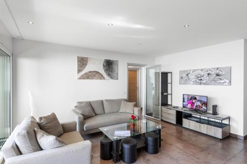 una sala de estar con un sofá y una mesa en Art Apartment - Happy Rentals, en Locarno