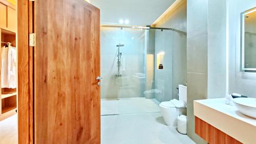 een badkamer met een douche, een toilet en een wastafel bij VILLA VALITO in Kuta Lombok