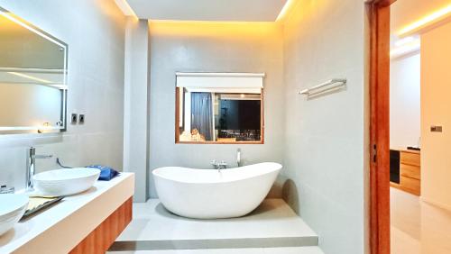a bathroom with a large white tub and two sinks at VILLA VALITO in Kuta Lombok