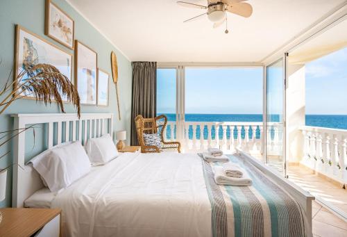 una camera con letto e vista sull'oceano di 3 Front Line Beach house Playa Paraiso Manilva a Manilva