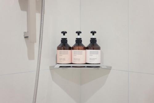 three bottles of wine sitting on a shelf in a bathroom at Aank Air Hotel Daejeon in Geochang