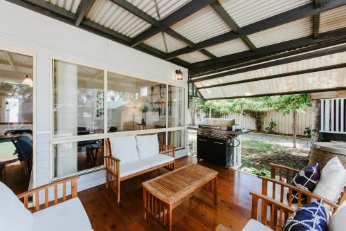 a screened in porch with a couch and a table at 'The Nicholson' A Central and Charming Cottage in Mudgee in Mudgee