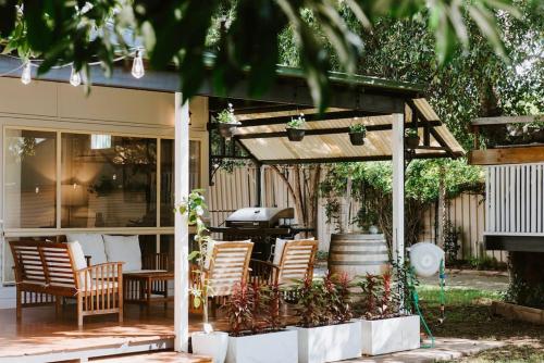 a pergola with chairs and a grill on a patio at The Nicholson - A Delightful Family Escape Awaits in Mudgee