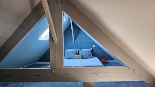 an attic room with a bed in the attic at Studio cosy au bord de mer in Lancieux