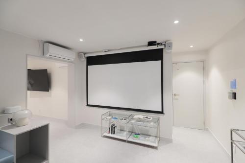 a large screen in a room with a white wall at Aank Air Hotel Daejeon in Geochang