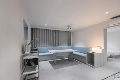 a living room with a blue couch and a table at Aank Air Hotel Daejeon in Geochang