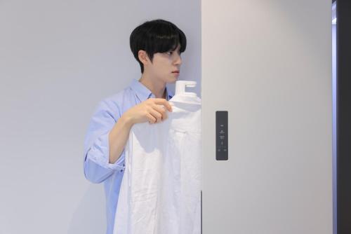 a man in a white shirt holding a white towel at Aank Air Hotel Daejeon in Geochang