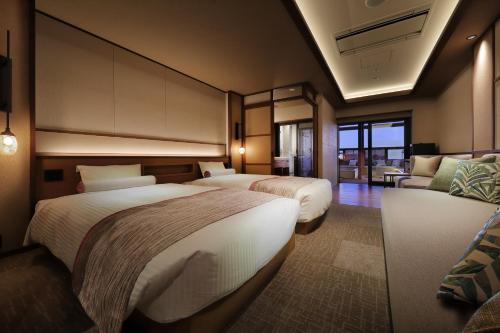a hotel room with two beds and a couch at Senri no Kaze in Tateyama